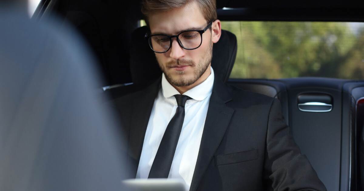 Close view of a chauffeur in formal attire checking the time, representing compliance and punctuality standards