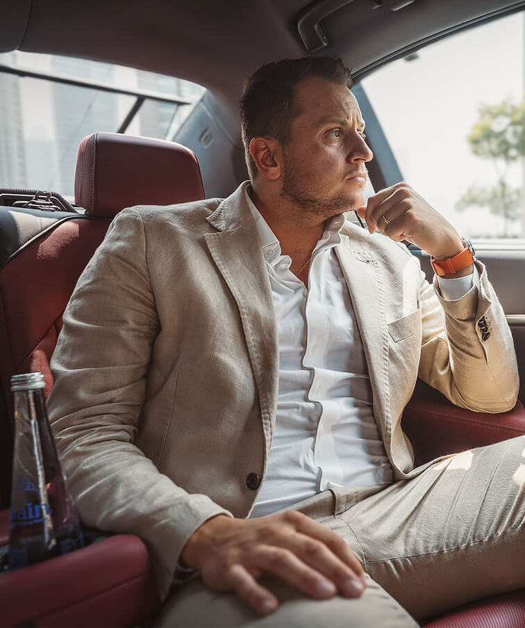 Premium chauffeur service passenger sitting comfortably inside a luxury car